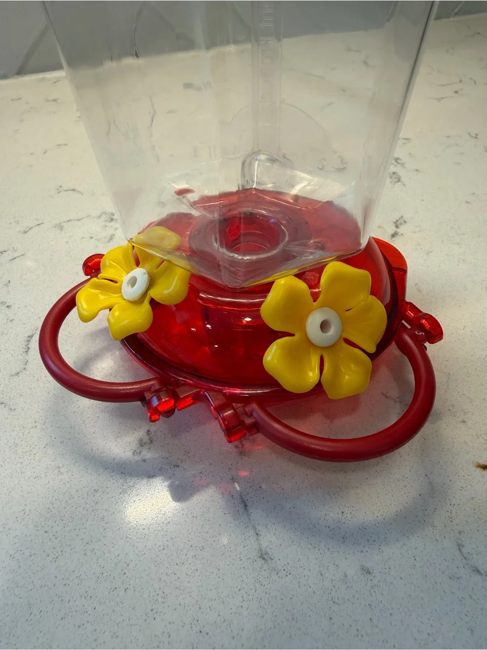 Clear Plastic Hummingbird Feeder with Red Base and Yellow Flowers